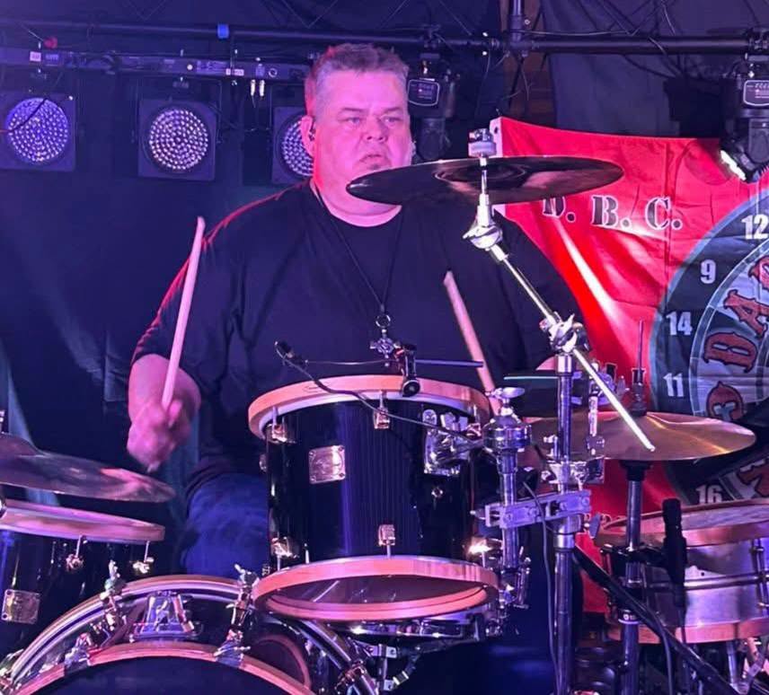 Joe MacMillan playing drums on stage